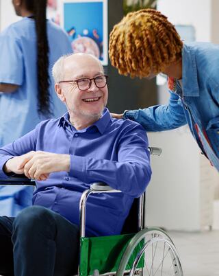 physician consulting senior man in a wheelchair